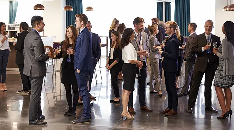 Photo of a group of people networking and smiling