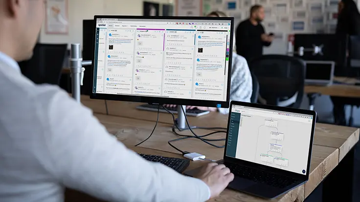 Spotler-collega achter een scherm met monitoring dashboard. 